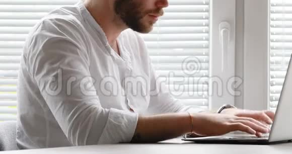一个人在电脑上打字然后看着相机视频的预览图
