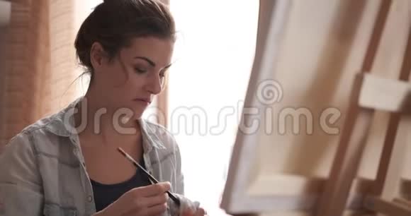 女艺术家用餐巾擦拭画笔视频的预览图