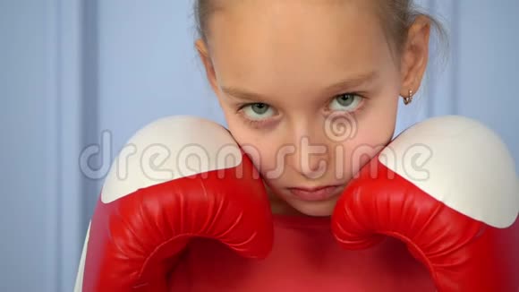 关闭运动的年轻女孩做拳击运动直接击中年轻女孩被隔离在蓝色背景上实力视频的预览图