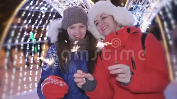 那天晚上母亲和女儿在城里的圣诞晚会上玩得很开心还和火花舞在一起视频的预览图