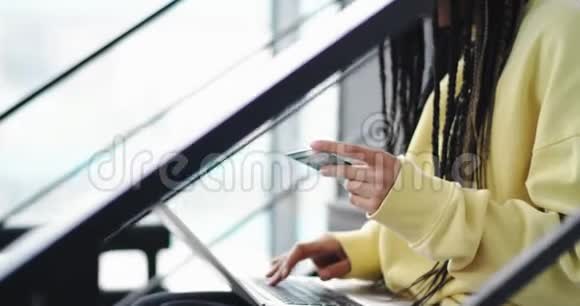 一位美丽的非洲女人在楼梯上的现代办公大厅里戴着可怕的公鸡她在网上做了交易视频的预览图