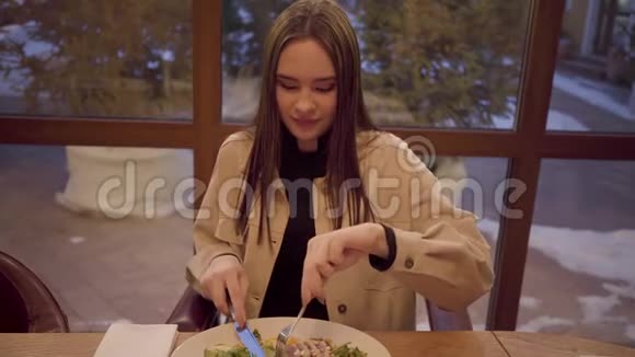 一个可爱的女孩在餐馆吃饭的肖像女士喜欢吃一道美味的新鲜蔬菜和视频的预览图