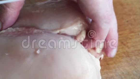 一个男人在木板上切鸡的特写镜头手切生鸡胸脯视频的预览图