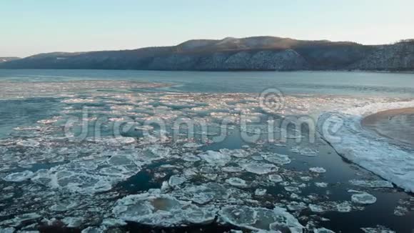 空中观景冰冻河流的足迹在给定的裸露的群山中覆盖着雪冬天寒冷的景色视频的预览图
