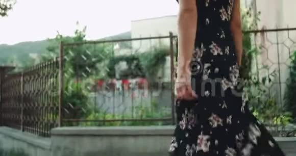 年轻的女士走在街上在一个夏天刮风的日子里穿着一件浪漫的视频的预览图
