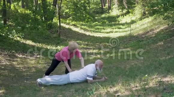 老妇人和丈夫在草地上做运动视频的预览图