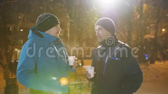 两个朋友在冬天在圣诞节市场交流喝咖啡视频的预览图