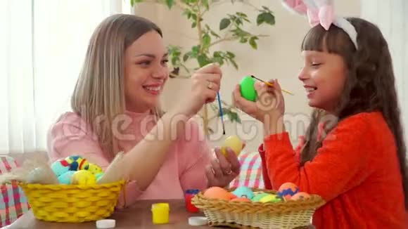 亲密的妈妈和女儿画复活节彩蛋然后刷痒对方鼻子视频的预览图