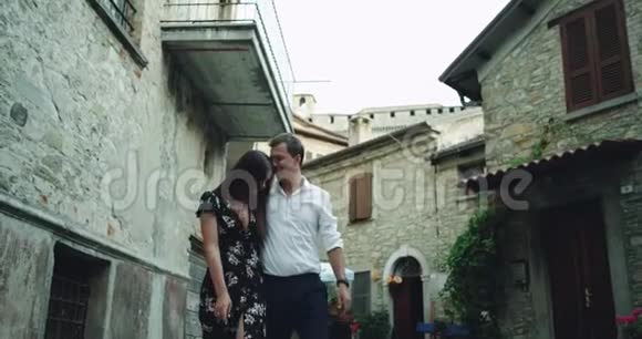 浪漫的年轻美女夫妇在意大利的一条老街中间有一条长廊他们互相看着对方视频的预览图
