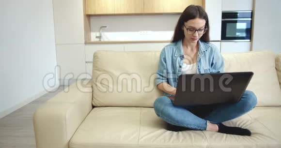 年轻女士在空平间打手提电脑视频的预览图