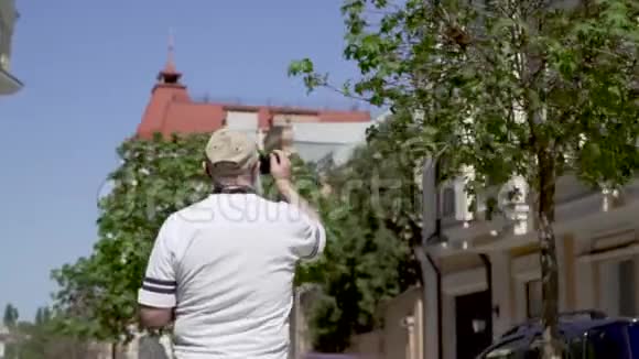 英俊的老人在城里散步和拍照的肖像视频的预览图
