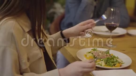 无法辨认的夫妇在现代咖啡馆里吃食物和喝酒女人吃沙拉和肉接近男子和妇女视频的预览图