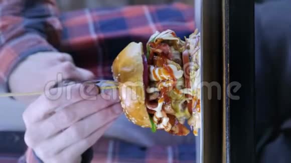 侍者或厨师把一个大汉堡切成两半街食品不健康垃圾食品肥胖和健康问题视频的预览图