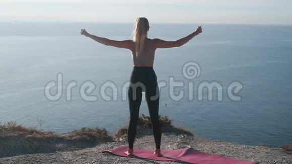 女人早上做运动和伸展运动背景是大海动作缓慢视频的预览图