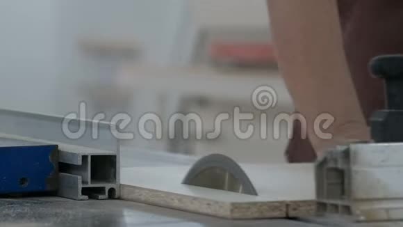 切割板材材料的机器圆锯切割一块白色叠层刨花板一个辅助特写的手工人视频的预览图
