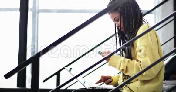 漂亮的非洲女人长着可怕的长着她用信用卡在网上买东西用笔记本视频的预览图