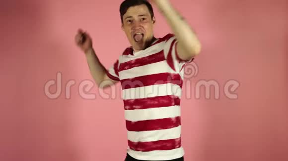 一个疯狂的人跳着微笑着双手放在自己身上脸上带着粉红色视频的预览图