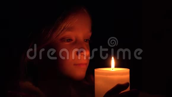 有蜡烛的快乐孩子夜晚的祈祷女孩黑暗中的孩子画像视频的预览图