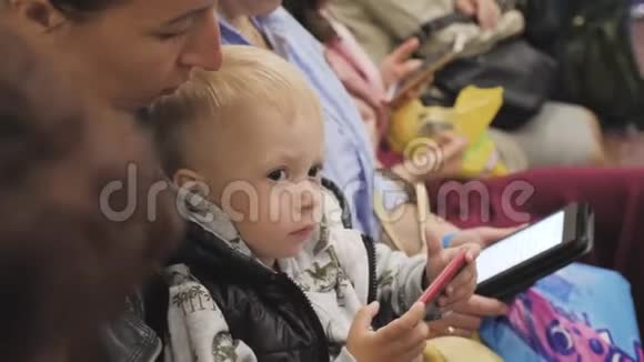 年轻的母亲和小儿子在乘地铁旅行时使用电话视频的预览图