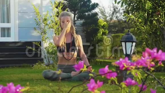 普拉纳亚玛瑜伽呼吸练习女子坐在后院莲花姿势视频的预览图