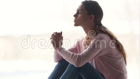 一个思想沉思的女孩独自坐着看着远方思考着视频的预览图