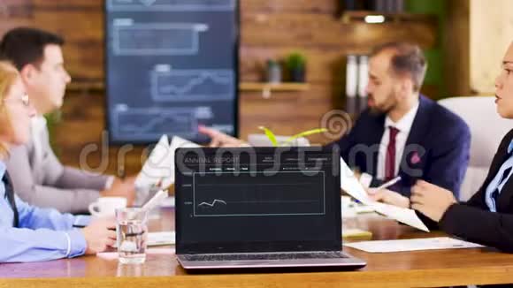 桌子上的笔记本电脑显示了会议室的图表视频的预览图