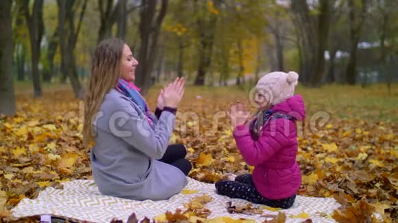 妈妈和女儿在秋天公园玩视频的预览图