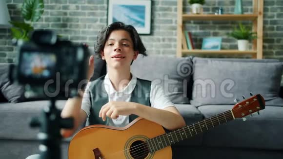 青少年男孩录制视频在线视频手持吉他说话手势视频的预览图