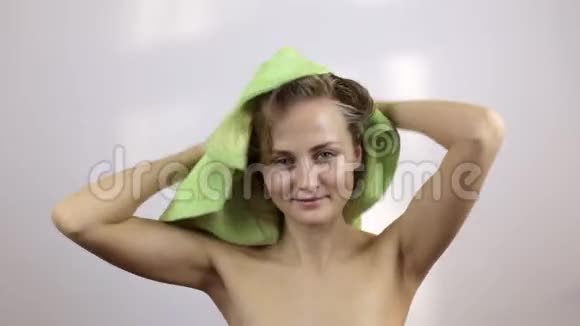 漂亮的女孩用浅绿色毛巾擦湿头发视频的预览图