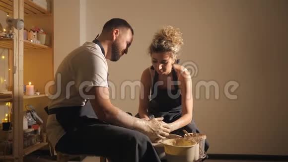 一个男人和一个女人在陶工轮子上做陶罐视频的预览图