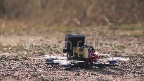 FPV赛车无人机从泥土表面起飞扬起灰尘和石头视频的预览图