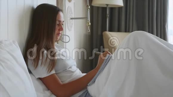 年轻女子在卧室里醒来后写日记视频的预览图