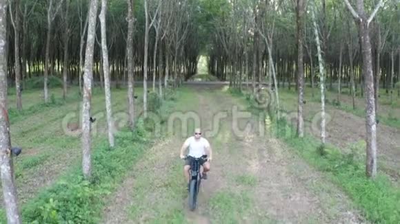 森林中电动自行车上人的鸟瞰图视频的预览图