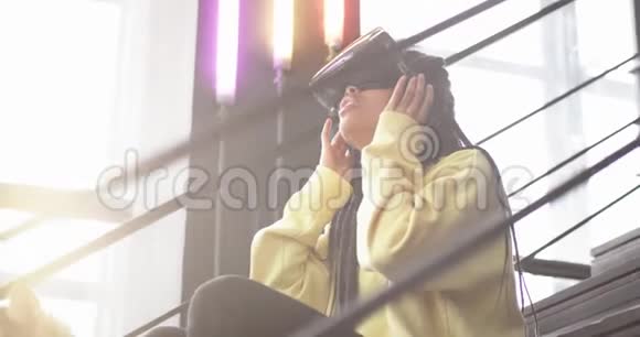 年轻的非洲女士带着她的哈士奇狗在现代办公楼的楼梯上女人探索她的VR眼镜视频的预览图