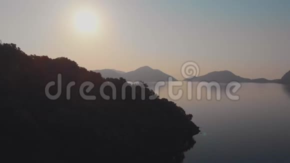 日落或日出平静的大海和山脉地平线上的太阳视频的预览图