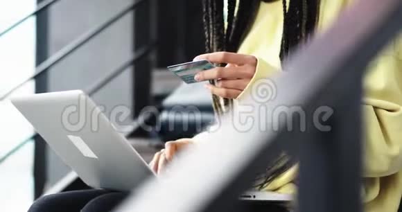 一位年轻的非洲裔女士的肖像细节用她的信用卡在笔记本上在线支付视频的预览图