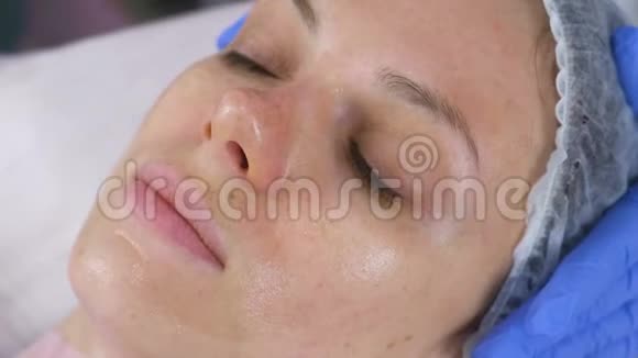 女人脸上戴着透明的面具美容师的面部护理视频的预览图