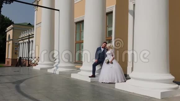 快乐的新婚夫妇站在公园的柱子上视频的预览图