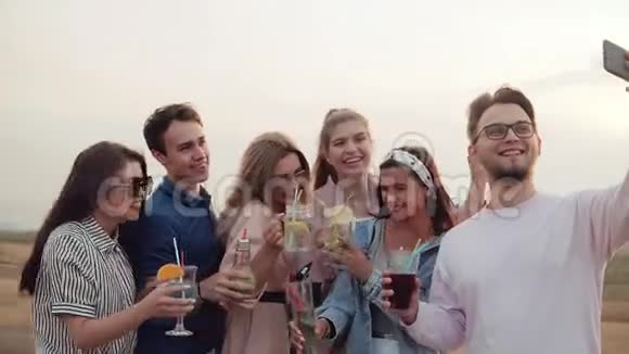 夏天在屋顶上的一群朋友喝鸡尾酒吃自拍夏季城市鸡尾酒视频的预览图