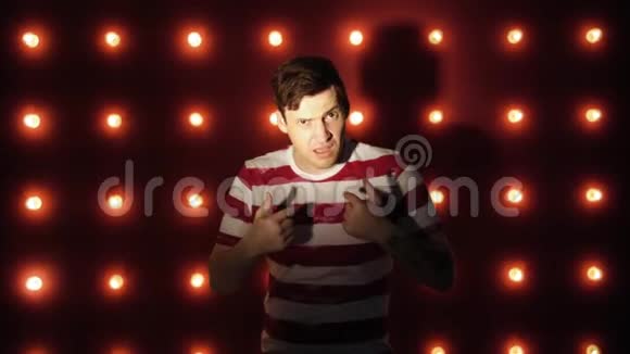 红色背景的漂亮男人用一只手指指着侧面视频的预览图
