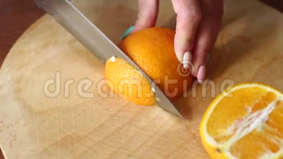特写女孩在木板上剪下一个成熟多汁的橘子高分辨率视频的预览图