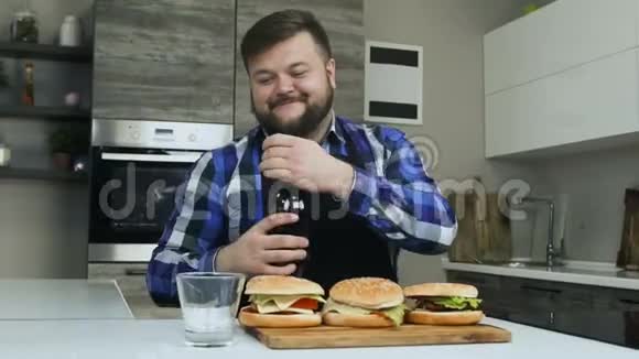 这位快乐的胖子把碳酸软饮料倒进玻璃杯里汉堡包已经准备好了不健康的生活方式油炸和视频的预览图