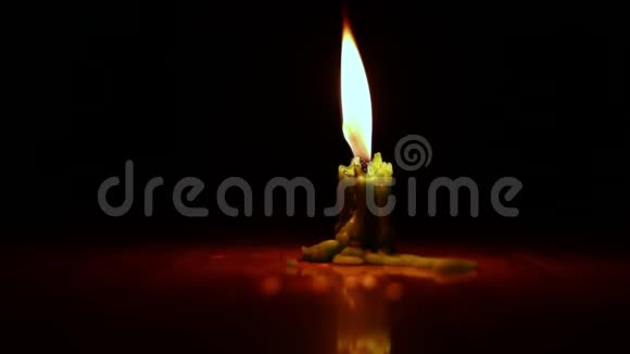 一支绿色的蜡烛在燃烧黑暗背景下的孤立蜡烛燃烧视频的预览图