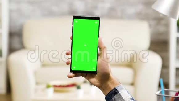 在客厅里竖着一个绿色屏幕手机视频的预览图