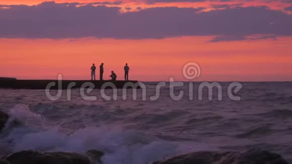 渔夫们正在美丽的日落的背景上钓鱼渔人夏日日落垂钓剪影视频的预览图