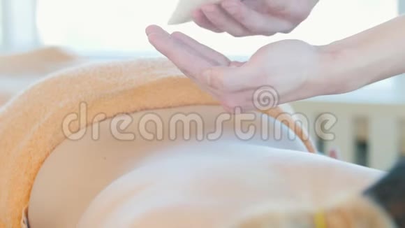 按摩会按摩师的手把奶油撒在女人背上视频的预览图