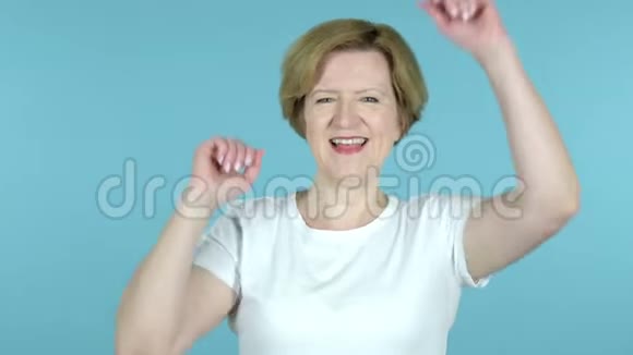 幸福的老女人在蓝底跳舞视频的预览图