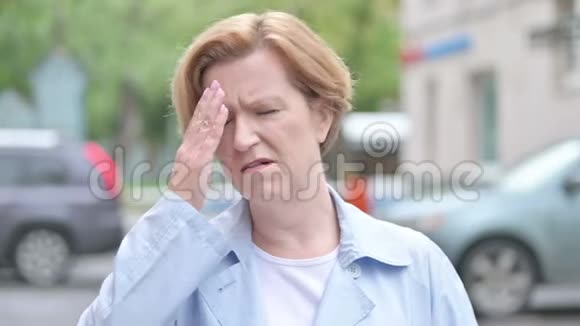有头痛的老女人站在户外视频的预览图