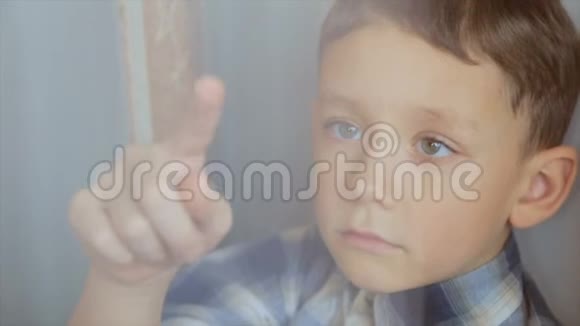 那个男孩用手指在窗户上视频的预览图