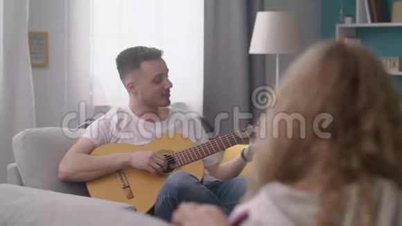 恐慌的人在一个舒适的客厅里为他的朋友弹吉他视频的预览图